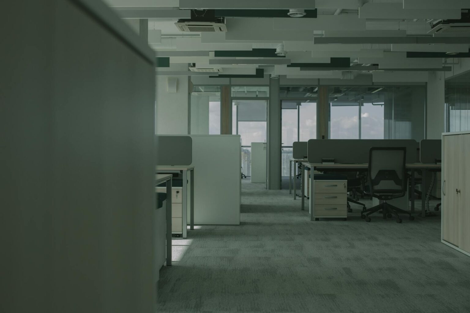 Empty modern office building interior showing vacant workspaces and desks