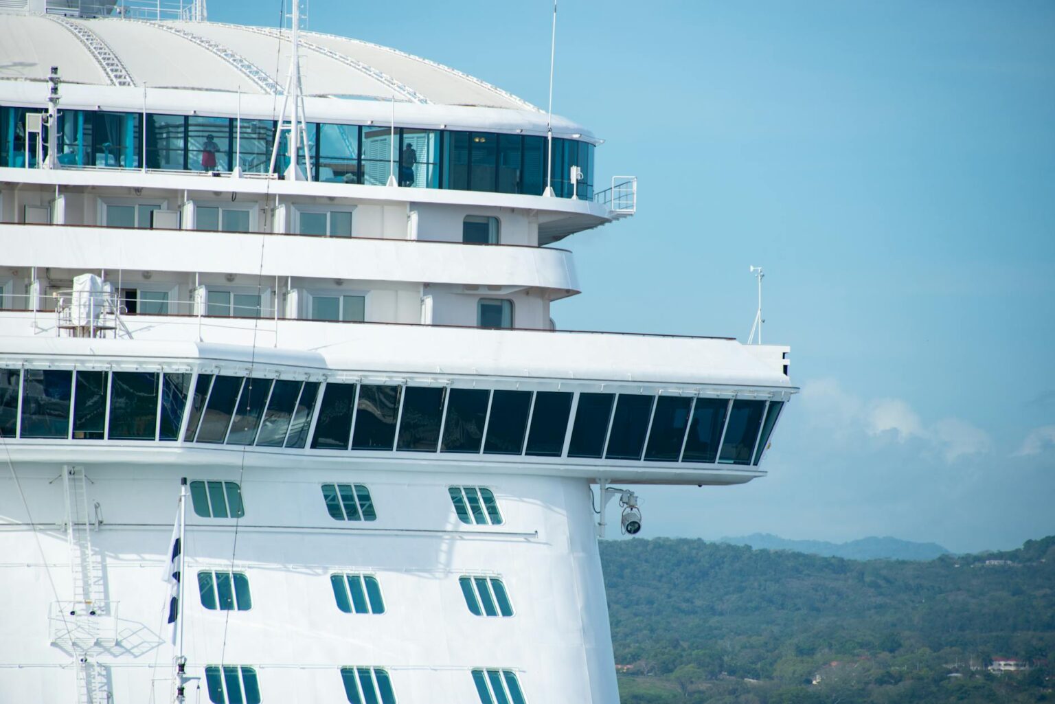 Large cruise ship sailing on blue ocean waters under clear sky