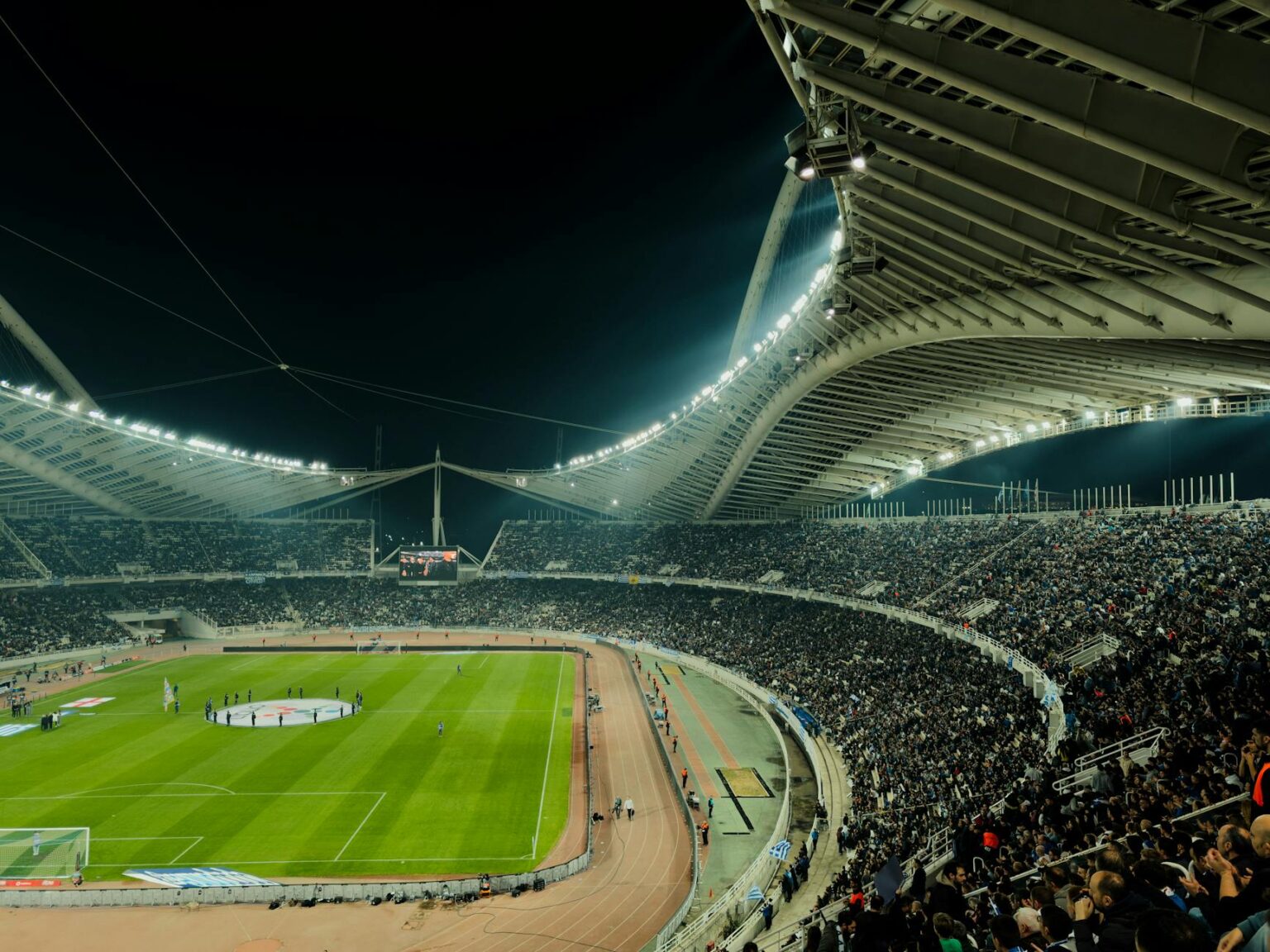 Sports fans using mobile phones in stadium seating area