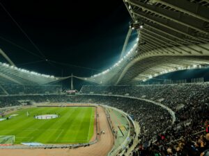 Sports fans using mobile phones in stadium seating area