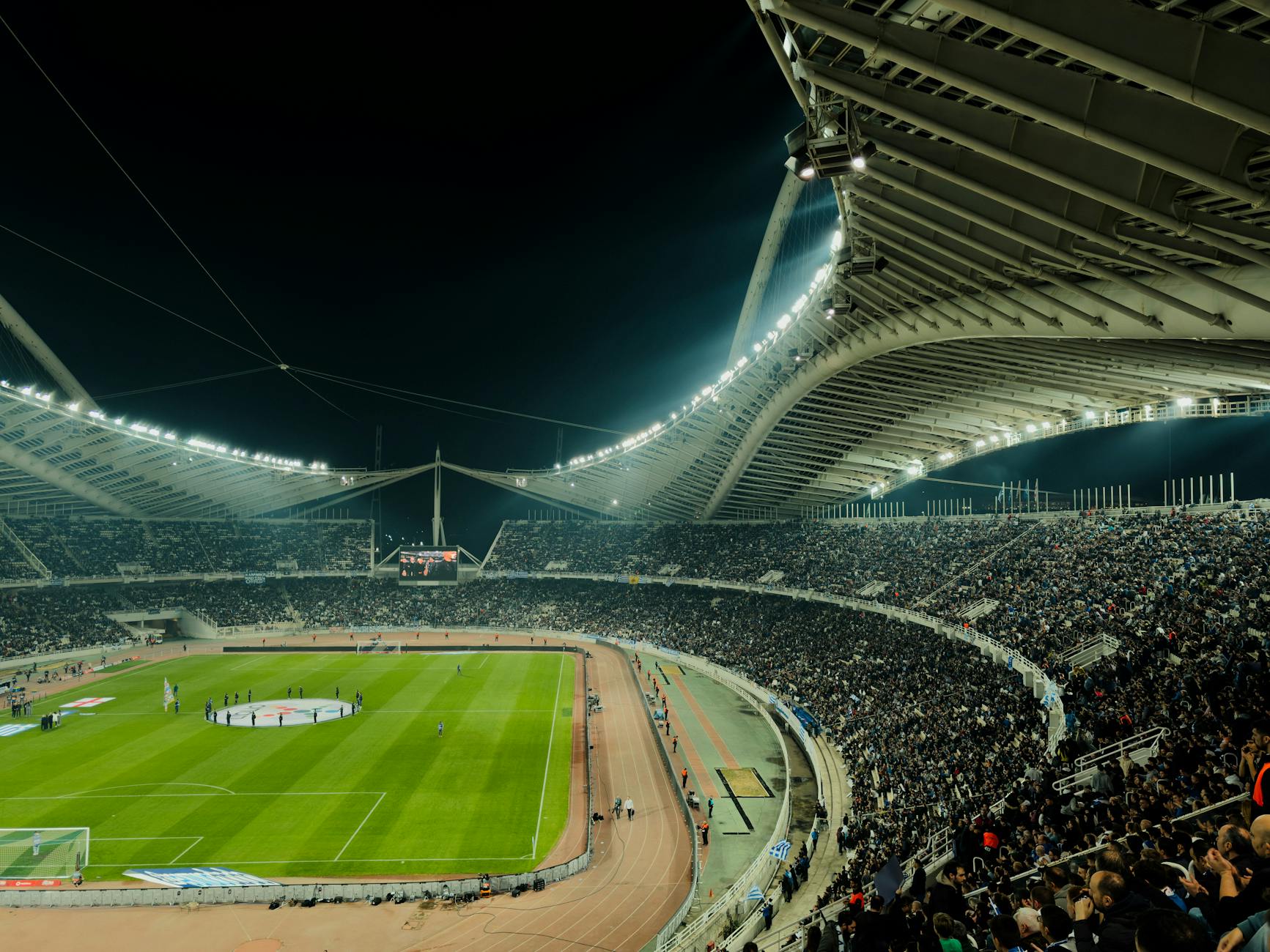 Sports fans using mobile phones in stadium seating area