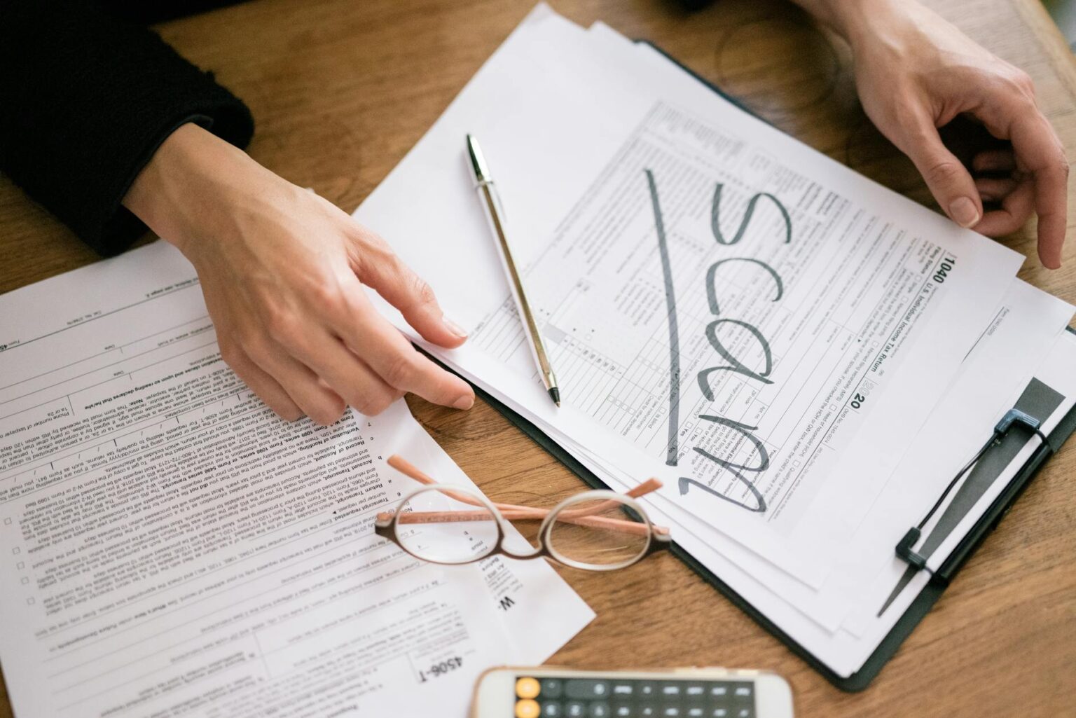 Financial documents and charts spread on desk showing investment analysis