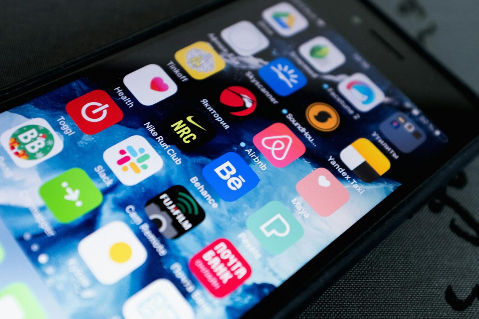 Close-up view of smartphone screen displaying various colorful mobile applications and app icons