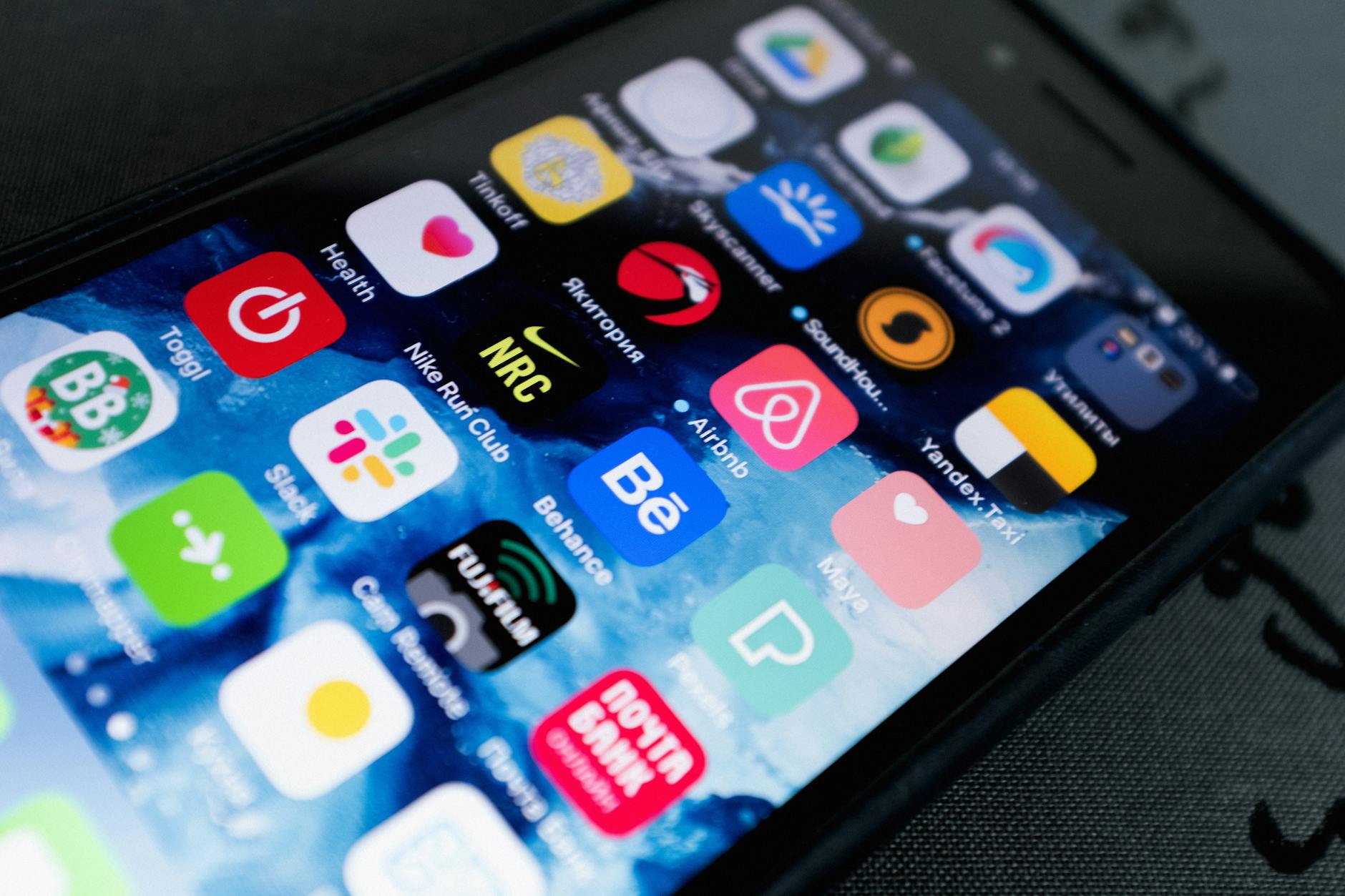 Person using smartphone to review property investment app showing real estate listings and portfolio performance