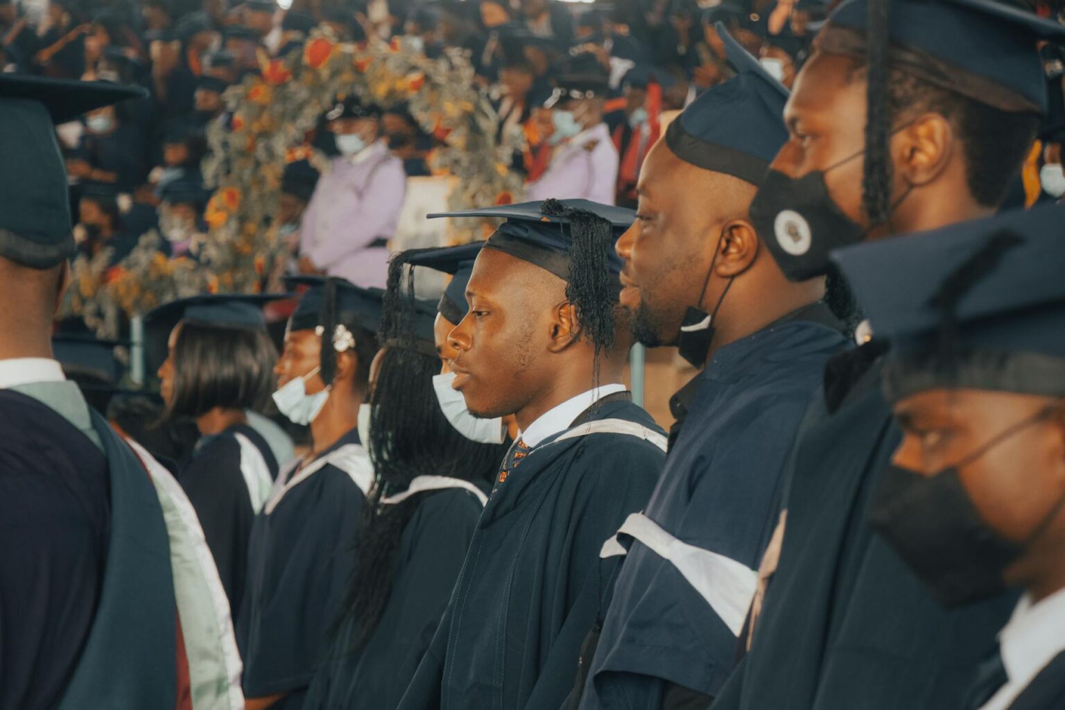 College graduates in caps and gowns celebrating at graduation ceremony