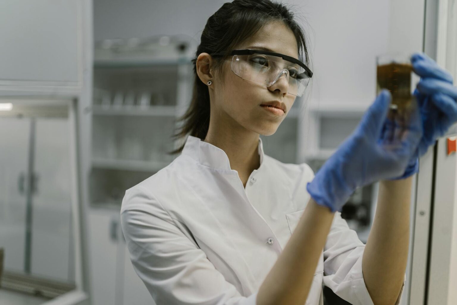 Scientist working in pharmaceutical laboratory with medical equipment and research materials