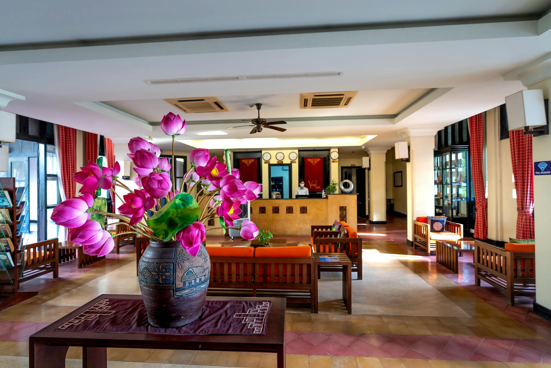 Modern hotel lobby with comfortable seating areas and people working on laptops