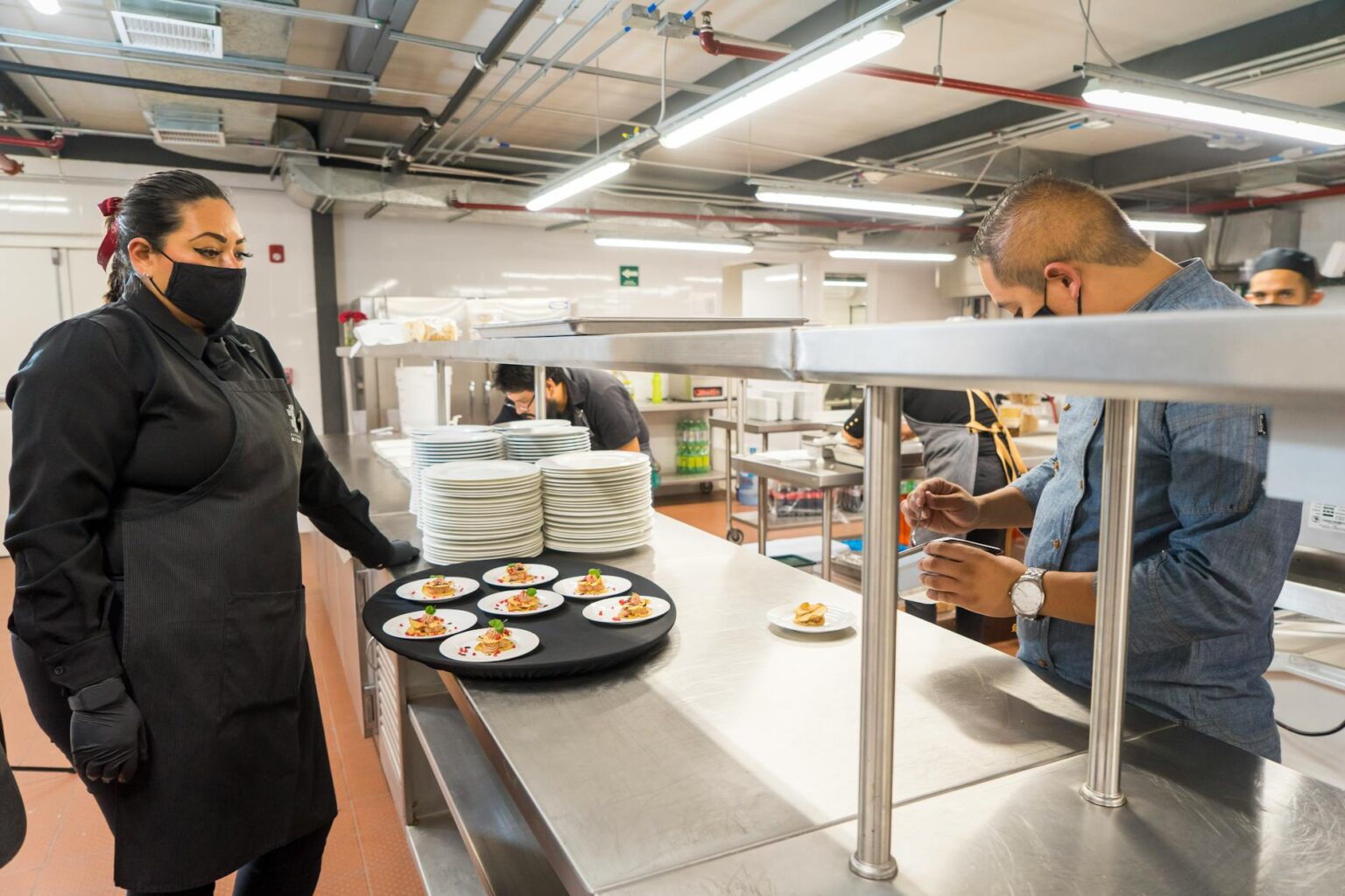 Modern commercial kitchen facility with stainless steel equipment and prep stations