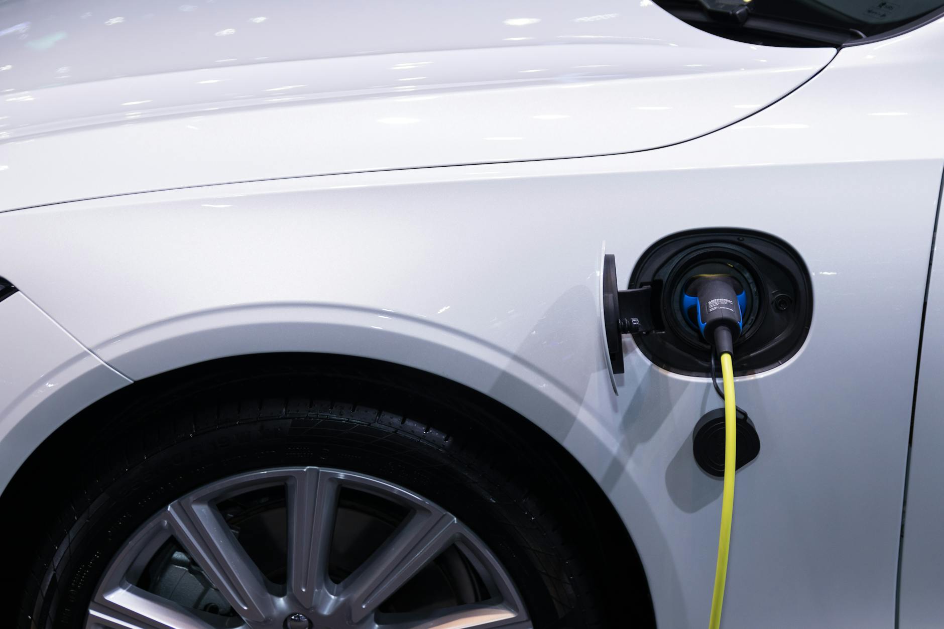 Electric vehicle connected to a charging station with charging cable plugged in