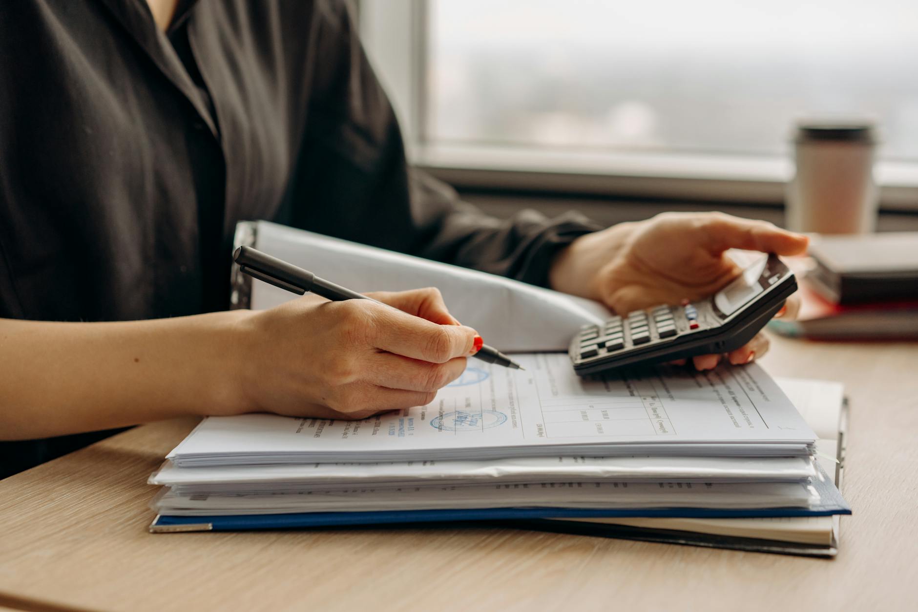 Calculator with financial documents showing mortgage calculations and interest rate impacts