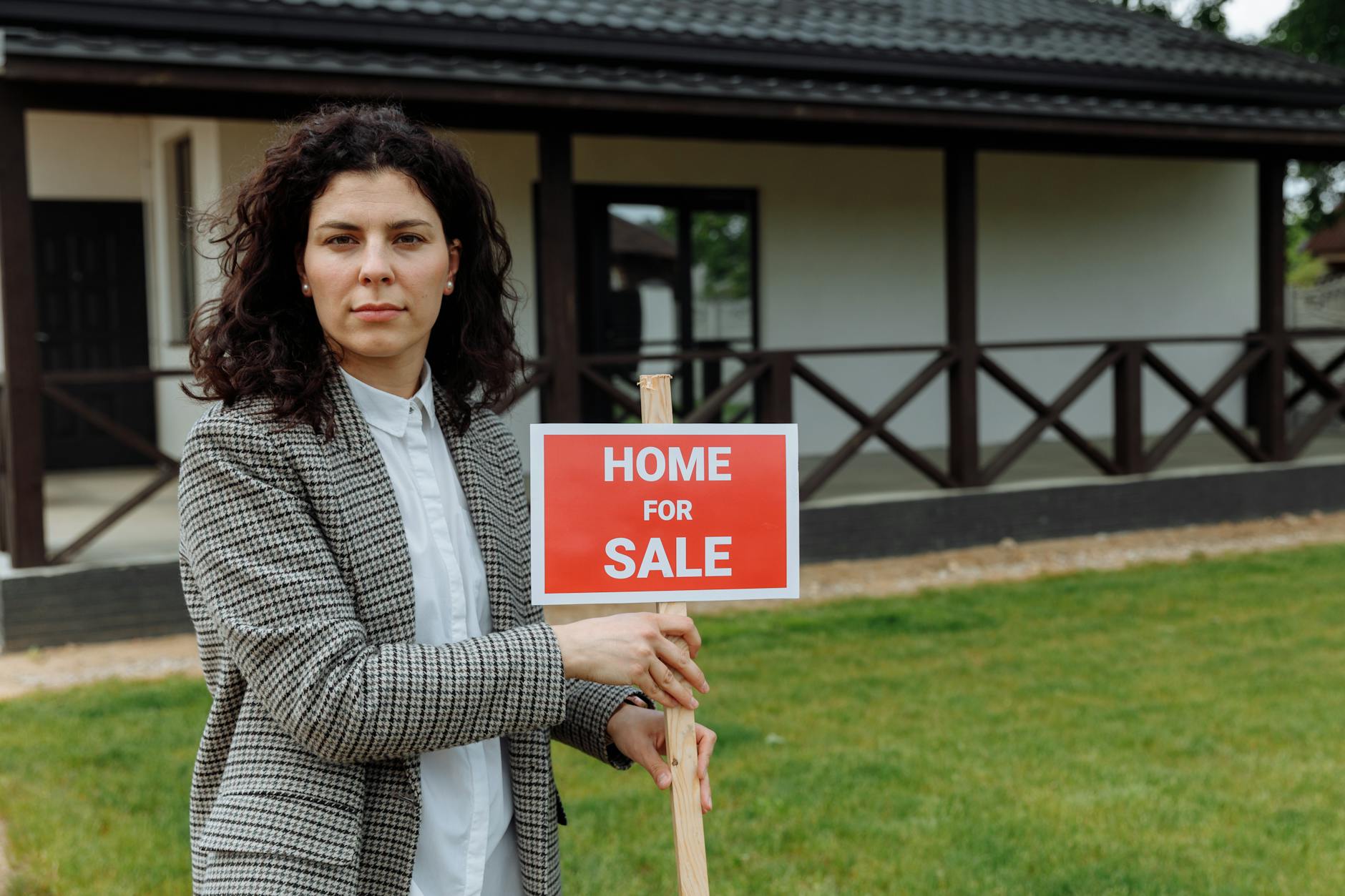 For sale real estate sign in front of residential house