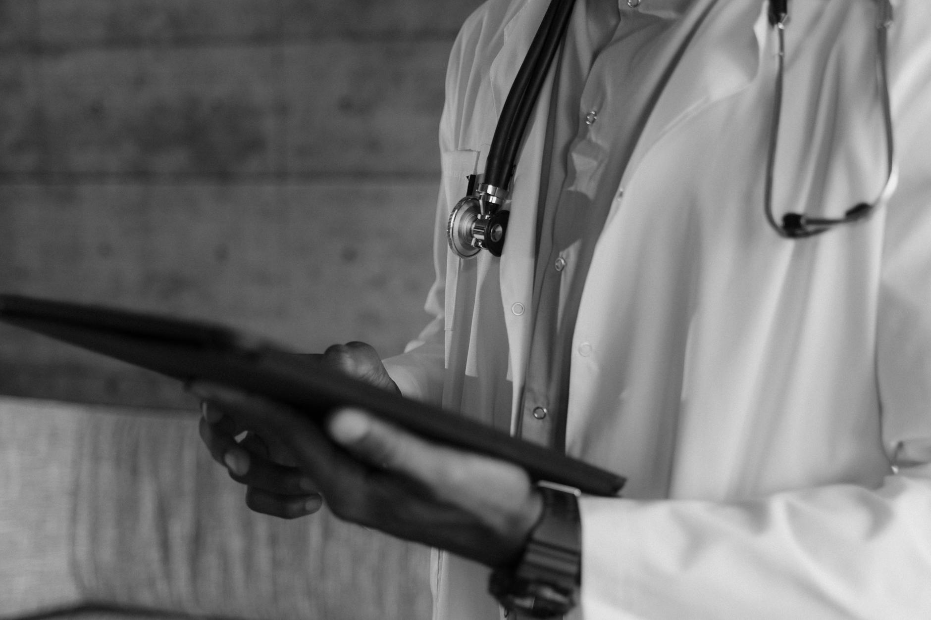 Healthcare professional using digital tablet with medical data and charts