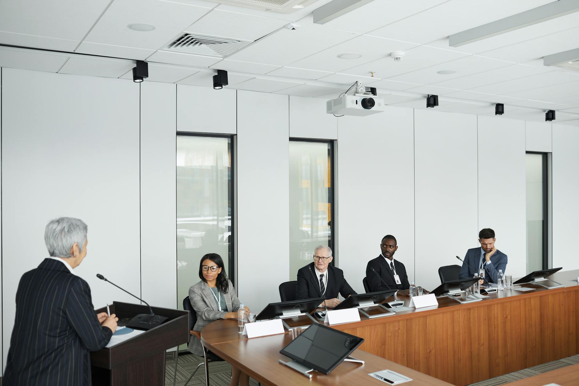 Modern tech conference presentation with audience viewing large screen display of company metrics