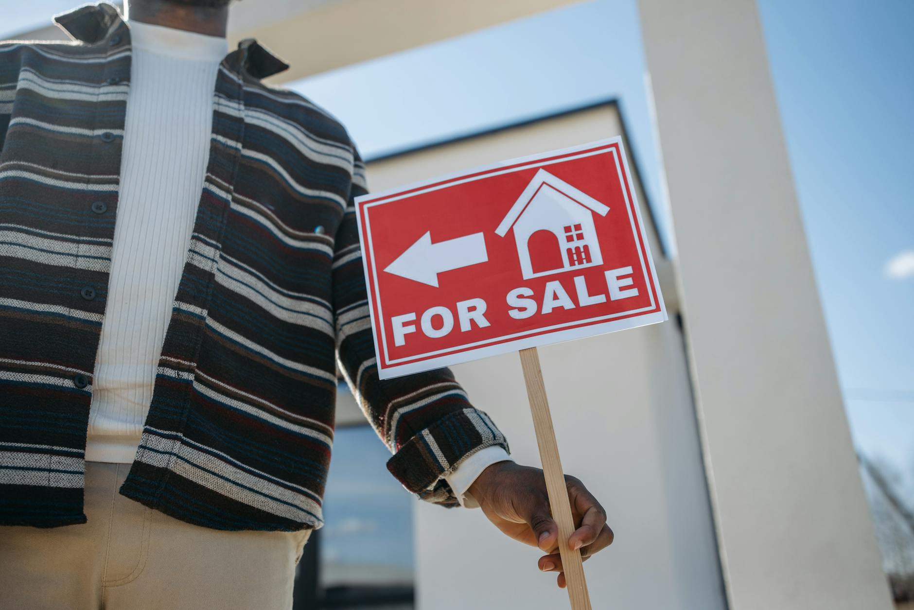 Real estate for sale sign in front of residential property
