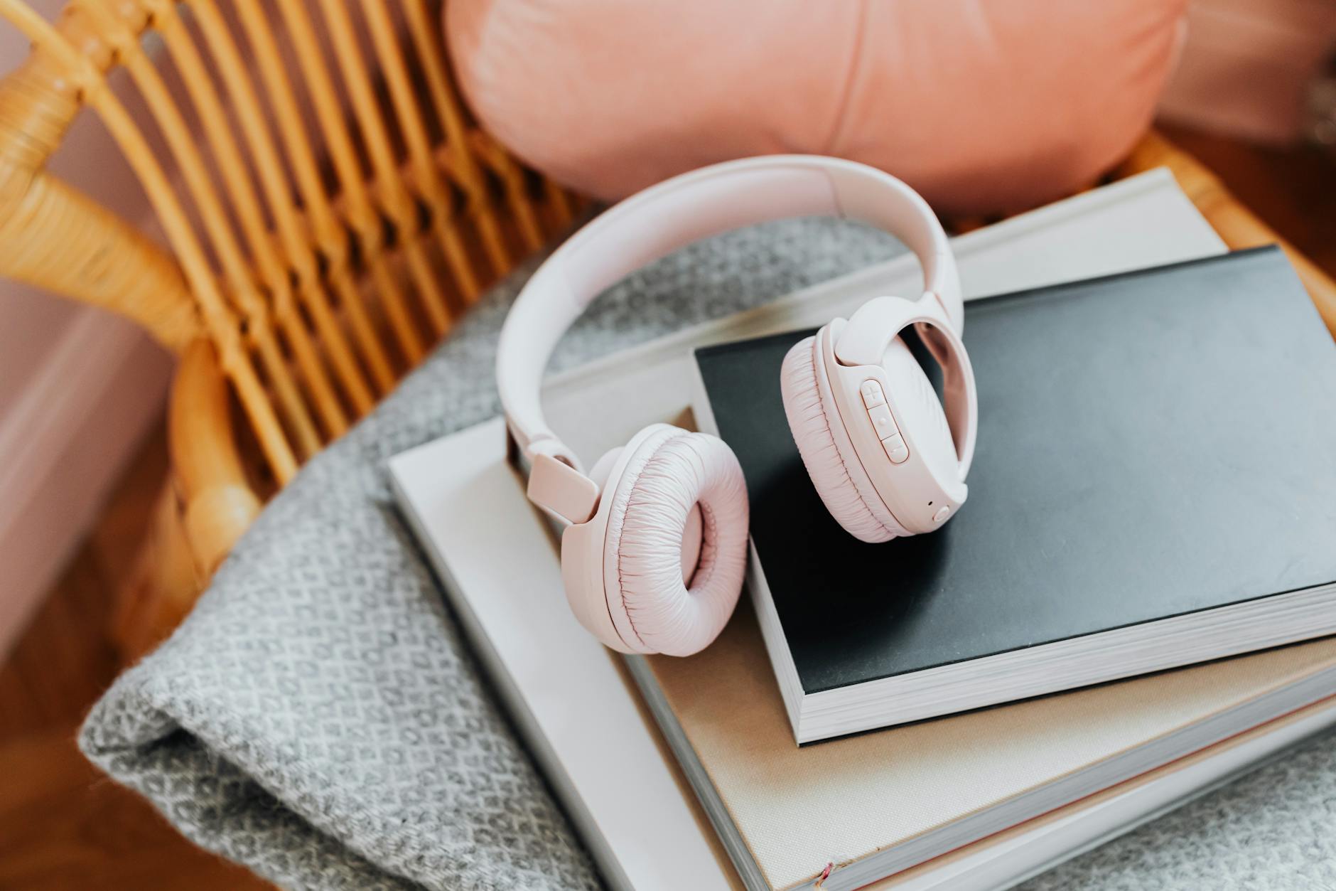 Stack of books with headphones representing audiobook and podcast content