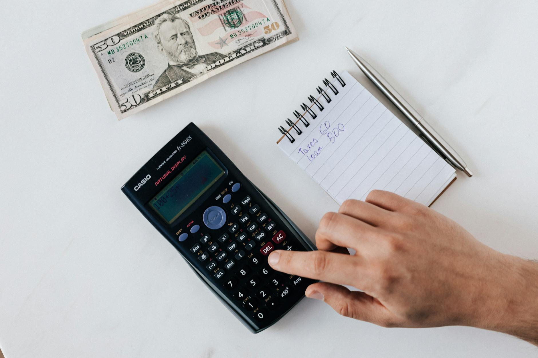 Financial documents and calculator showing loan calculations and paperwork