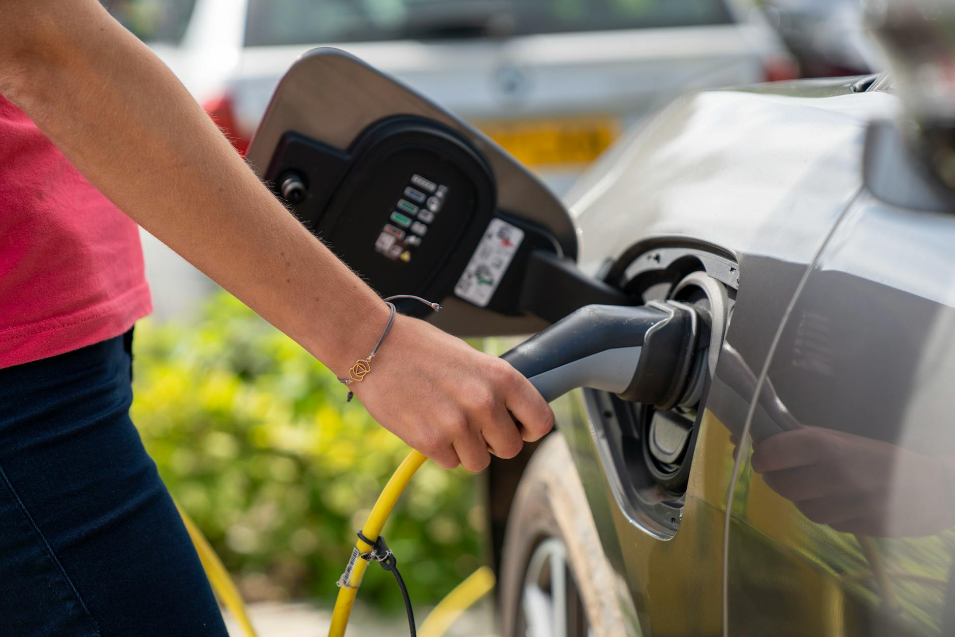 Electric vehicle connected to charging station in parking area