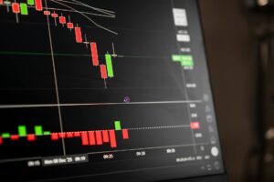 Multiple computer monitors displaying stock market charts and trading data
