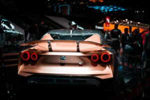 Modern vehicles displayed at an automotive exhibition with visitors examining latest models