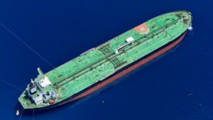 Large oil tanker vessel navigating through narrow waterway
