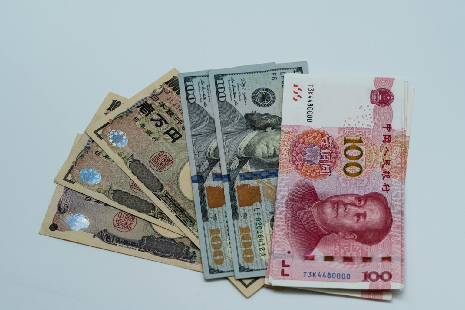 Multiple international currencies arranged on a trading desk