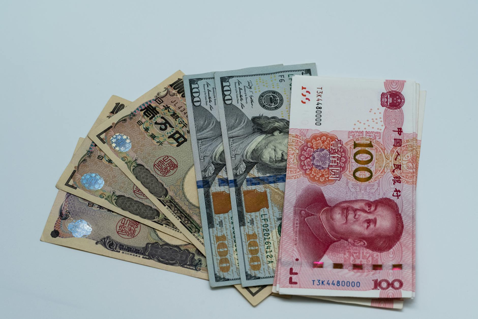 Multiple international currencies arranged on a trading desk