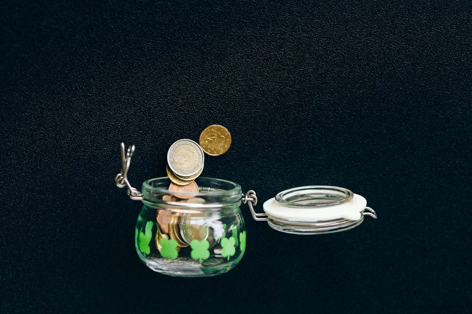 Glass jar filled with coins and bills representing savings and financial planning