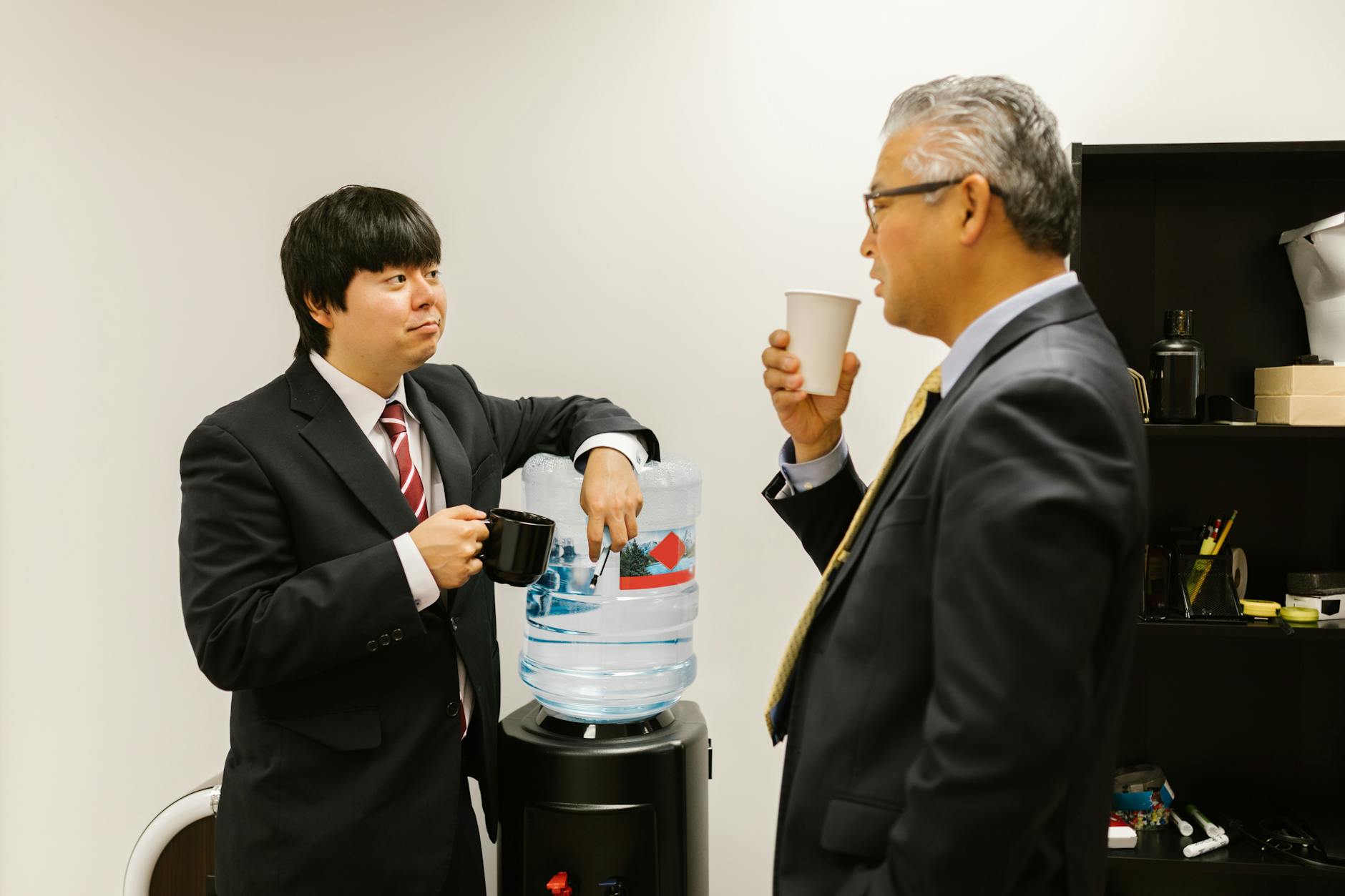 Two coworkers having a conversation in a modern office setting