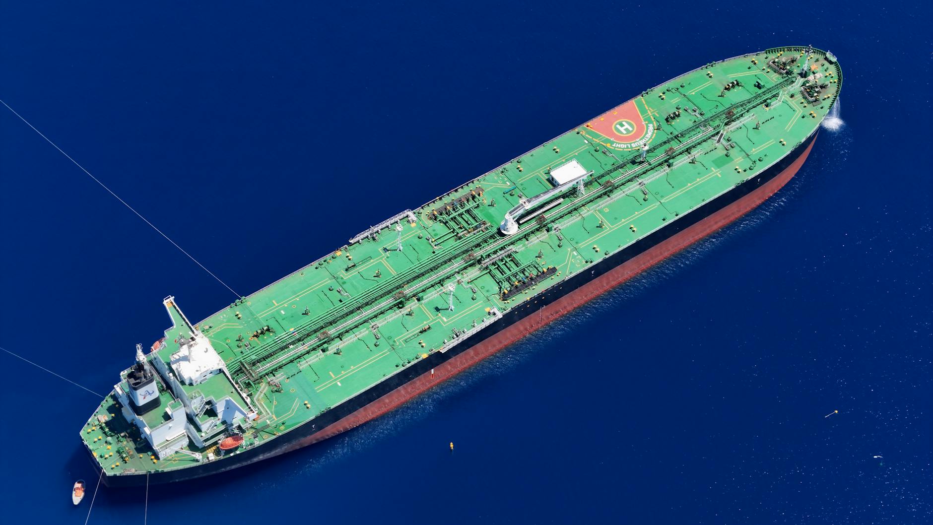 Large oil tanker vessel navigating through narrow shipping channel