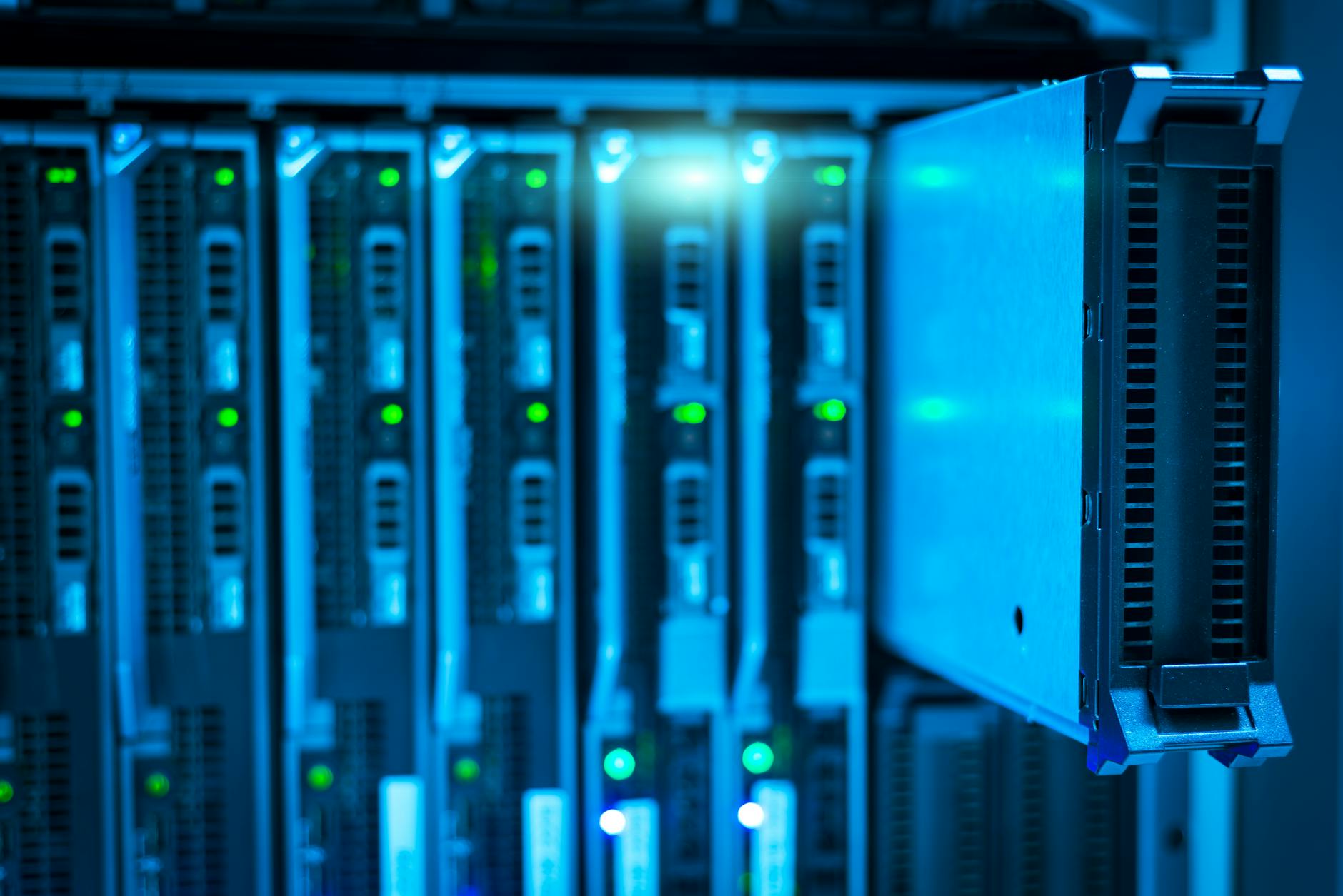 Rows of server racks in modern data center facility with blue lighting