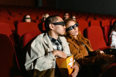 Empty movie theater with red seats facing large screen