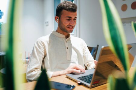 Young Father Builds Million-Dollar Net Worth Despite Low Pay Start Young professional working at desk with financial documents and calculator
