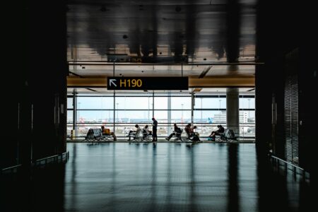 Travelers walking through a busy airport terminal during peak travel season