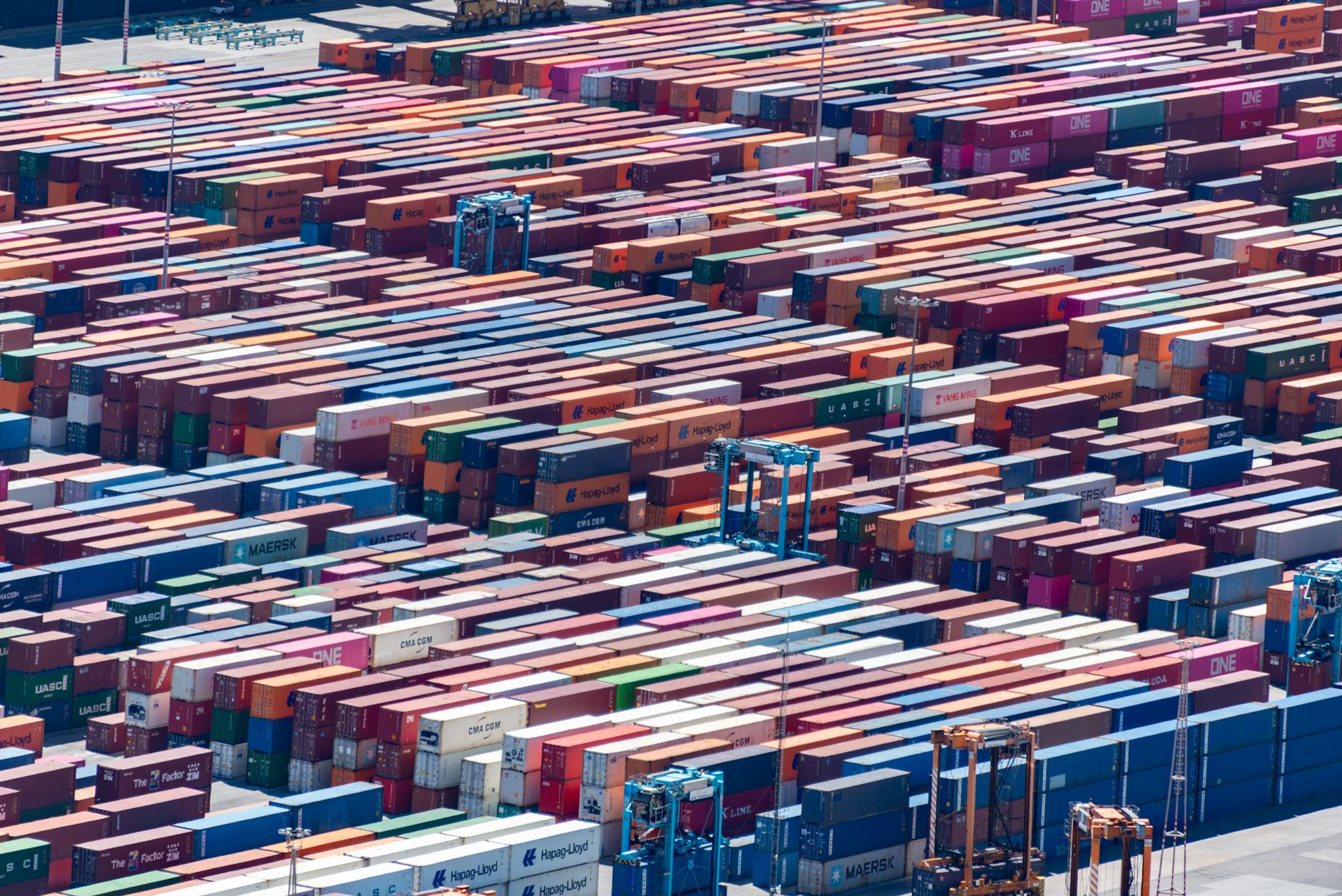 Busy commercial shipping port with container cranes