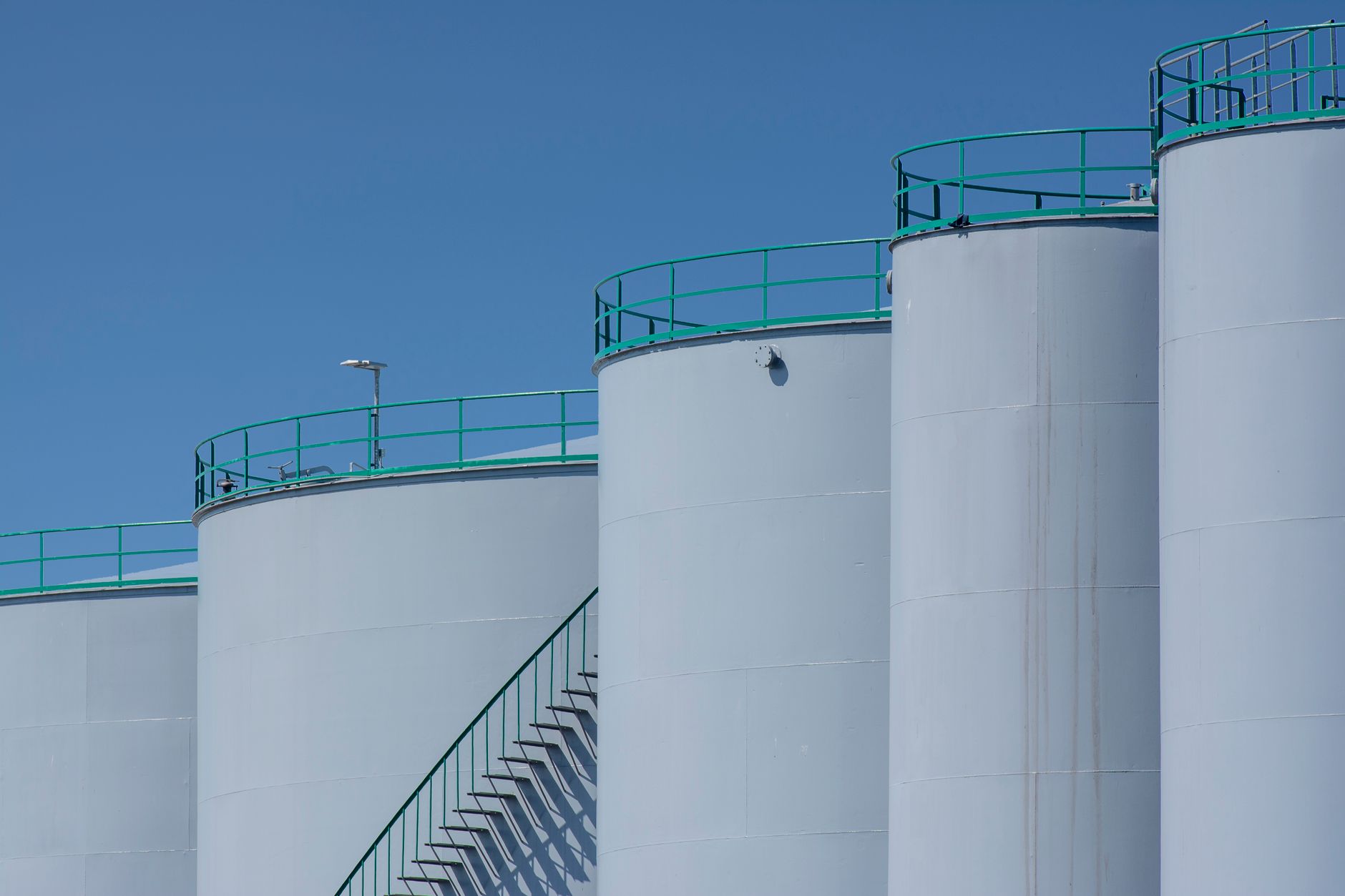 Industrial oil refinery facility with towers and pipelines at dusk