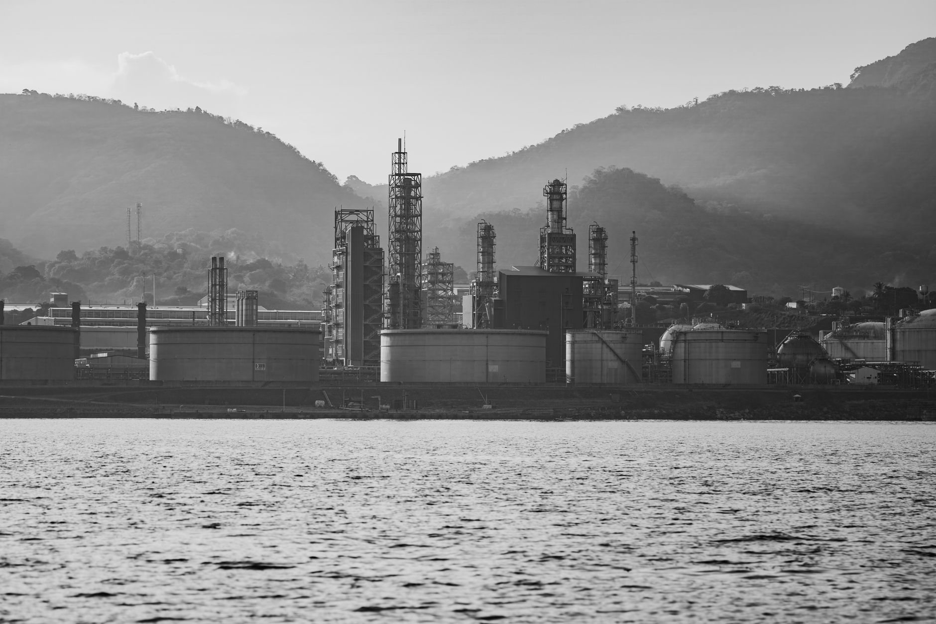 Industrial oil barrels at a refinery representing crude price movements
