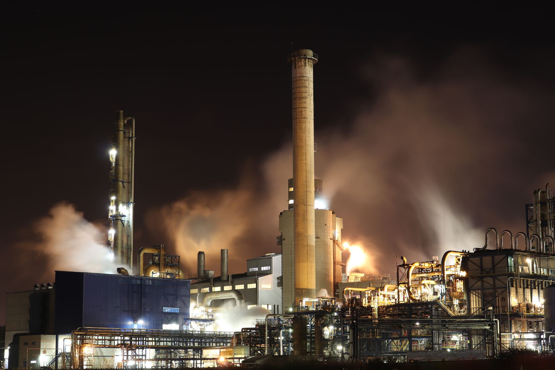 Industrial oil refinery with smoke rising from a damaged structure