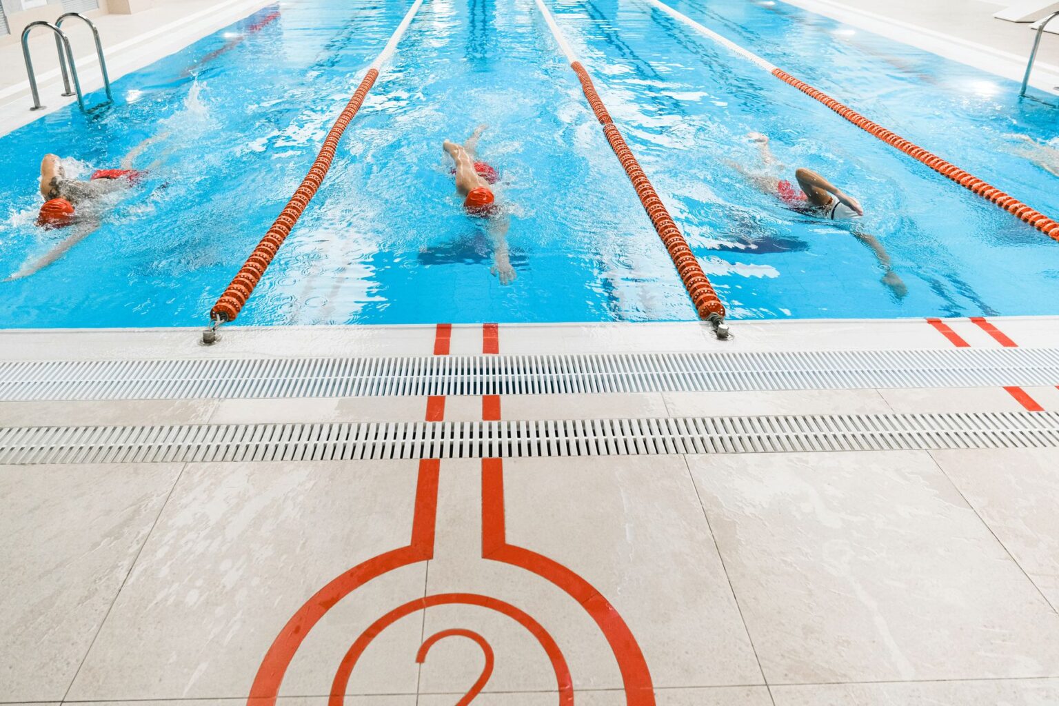 Empty competitive swimming pool with lane dividers viewed from above