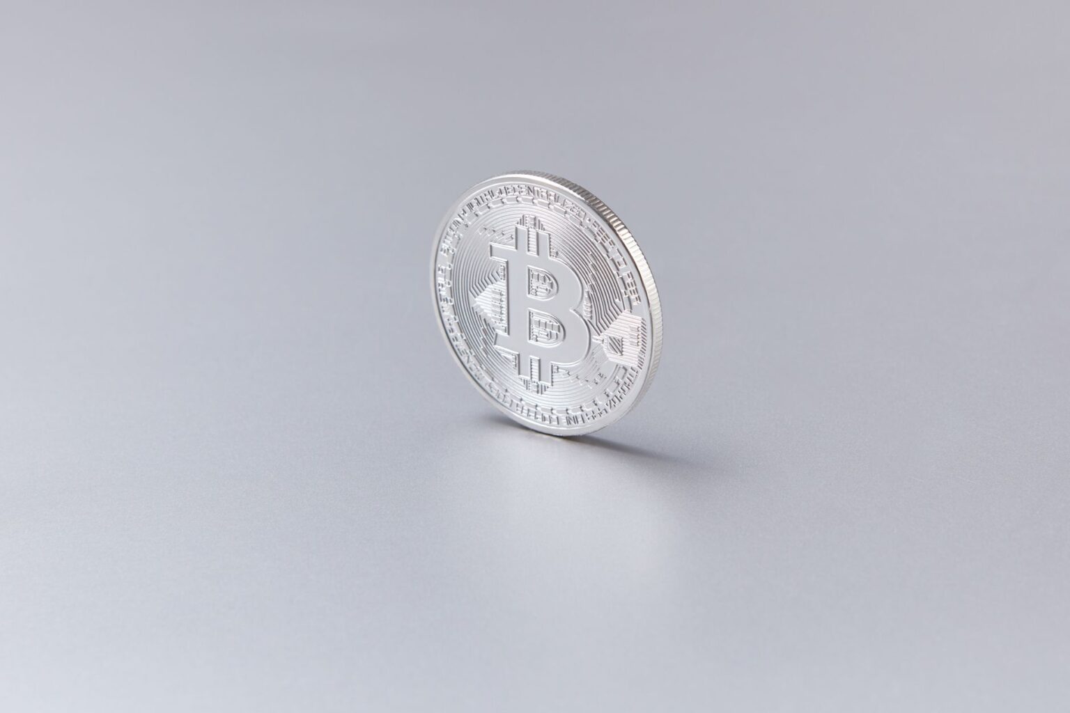 A physical bitcoin coin resting on a financial chart showing price movement