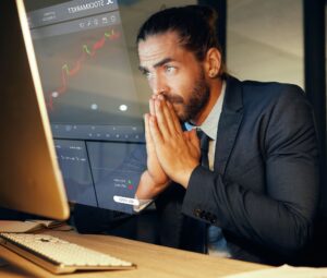 A trader watching stock market data on multiple screens