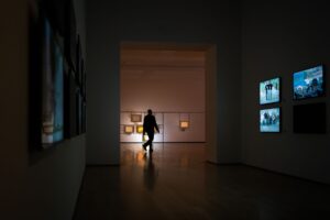 Visitors walking through a museum gallery filled with Asian art and artifacts