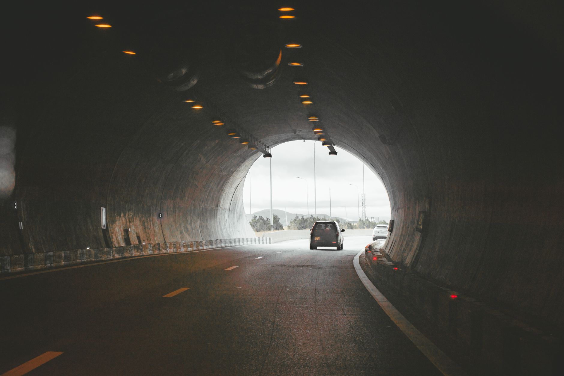 Electric vehicle driving through an illuminated tunnel