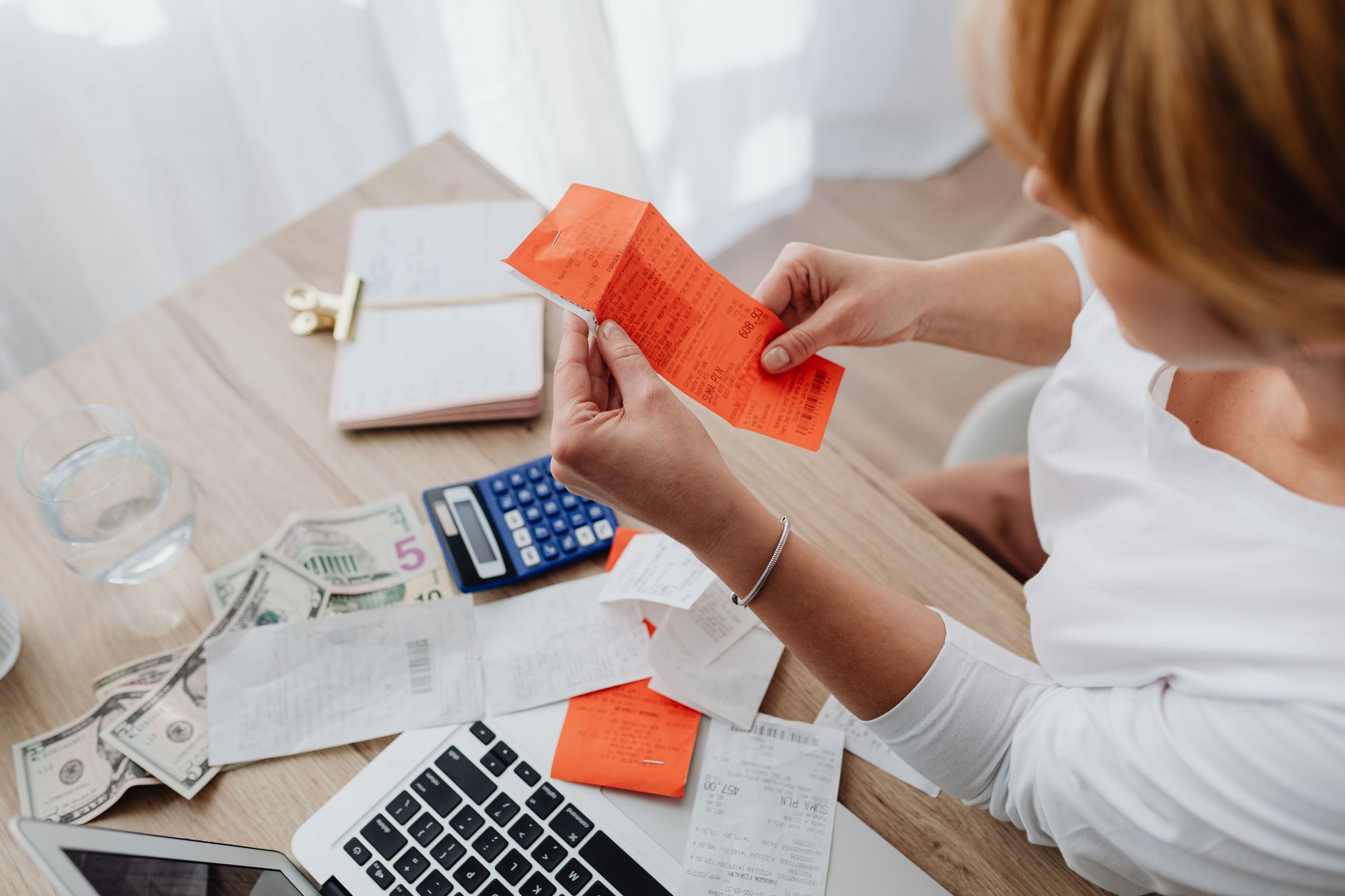 Person reviewing household budget at a desk representing rising consumer costs from fuel prices