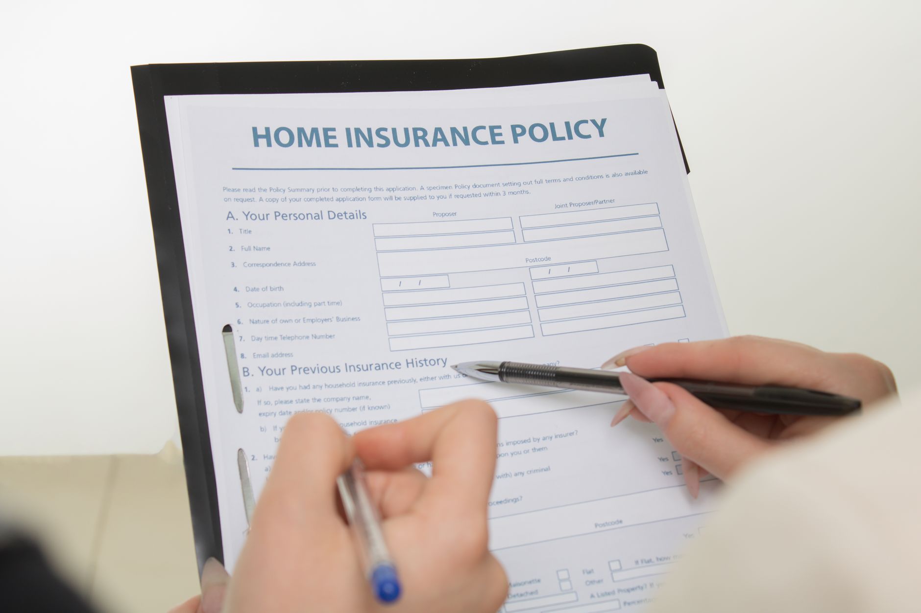 Homeowner reviewing insurance policy documents amid rising premium costs