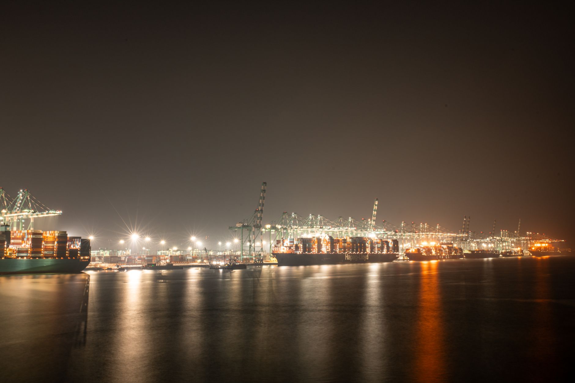 Cargo ships docked at a busy commercial port terminal